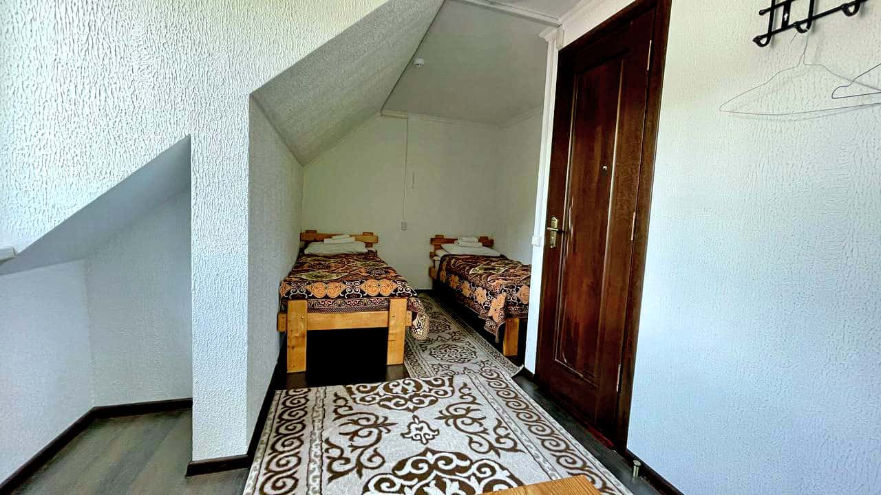 Twin room with wooden beds and patterned bedding at Alakol-Jyrgalan Guesthouse
